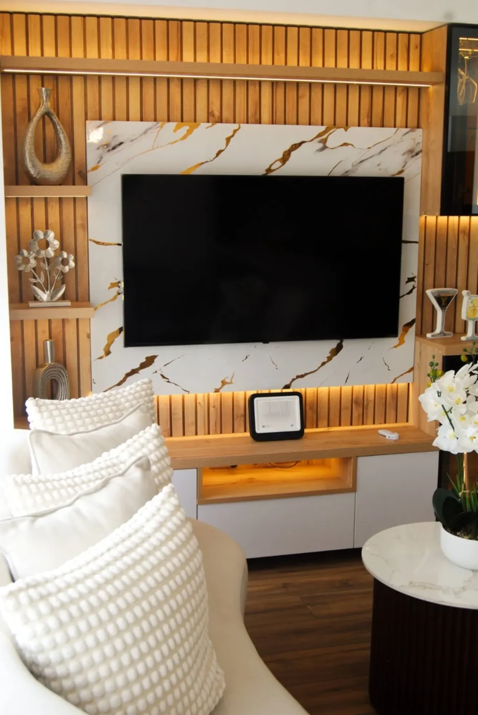 Living room with gold-lit wood feature wall